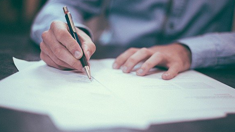 man signing documents