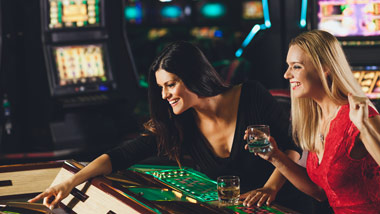 2 ladies playing a game at the casino