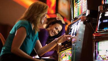 2 ladies playing at the slot machine