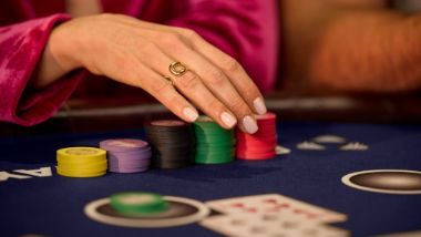 hand with poker chips on table